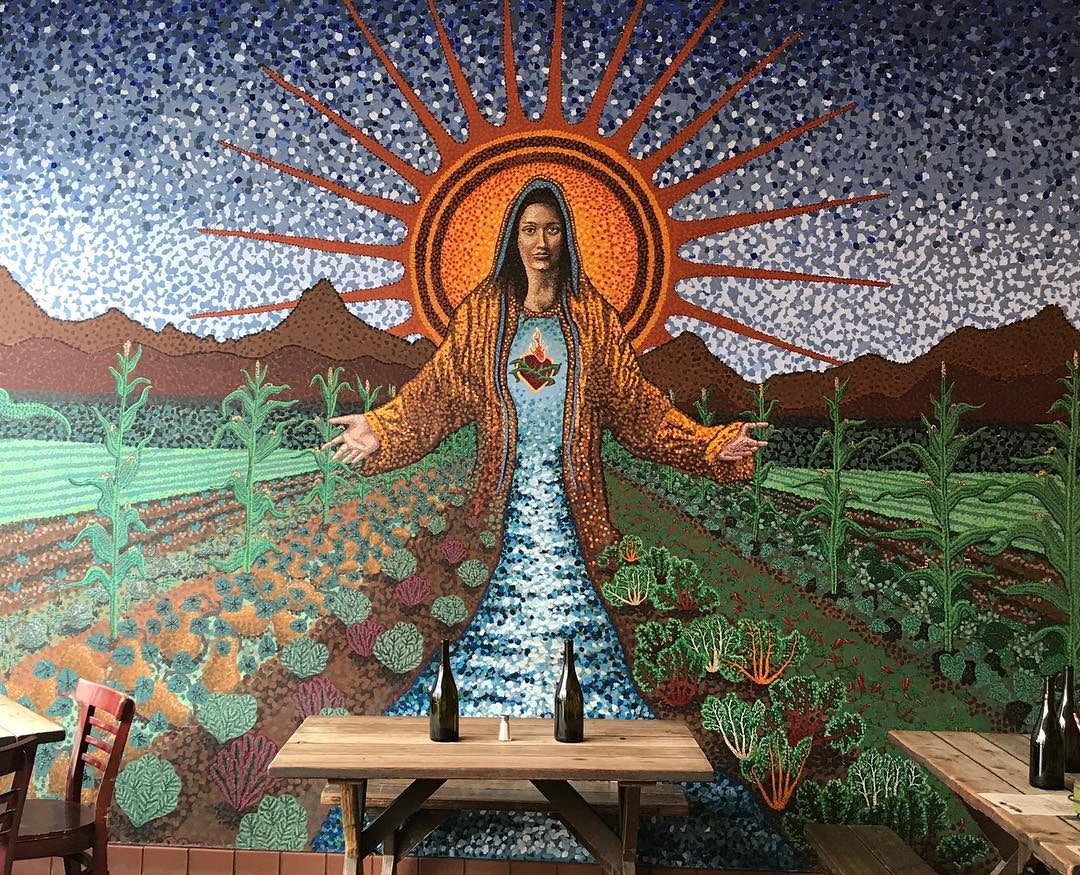 restaurant interior and wall painting of a saint at Gracias Madre