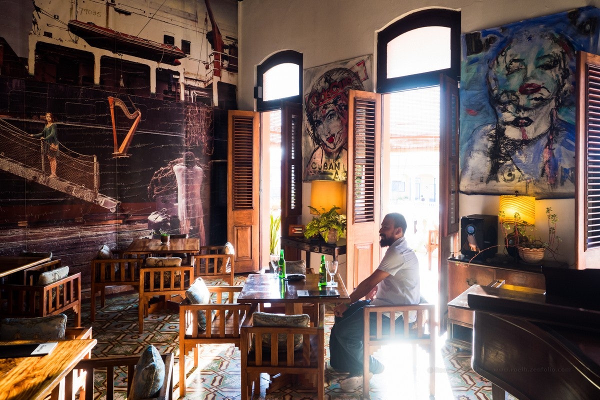 man sitting insde of Bar Madrigal in Havana