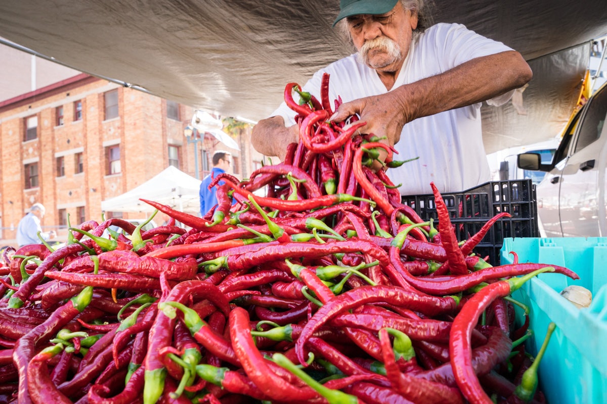 a man displaying chilli peppers the Farmers Market in Santa Monica