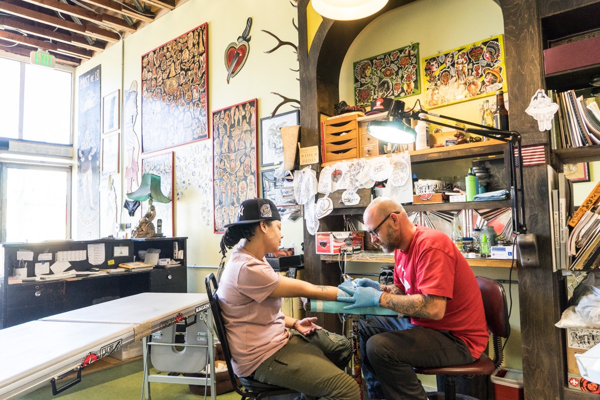 a man getting tattooed at the American Electric Tattoo Company