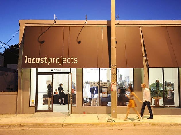 couple walking in front of Locust Projects store