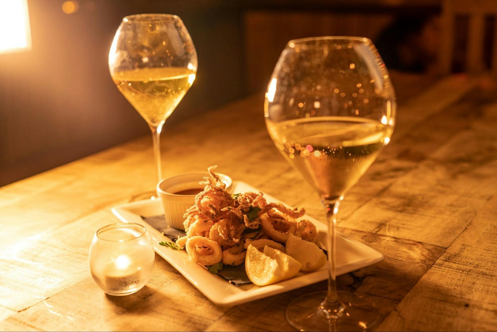 two glasses of white wine and fried baby squid at Via Verdi Miami