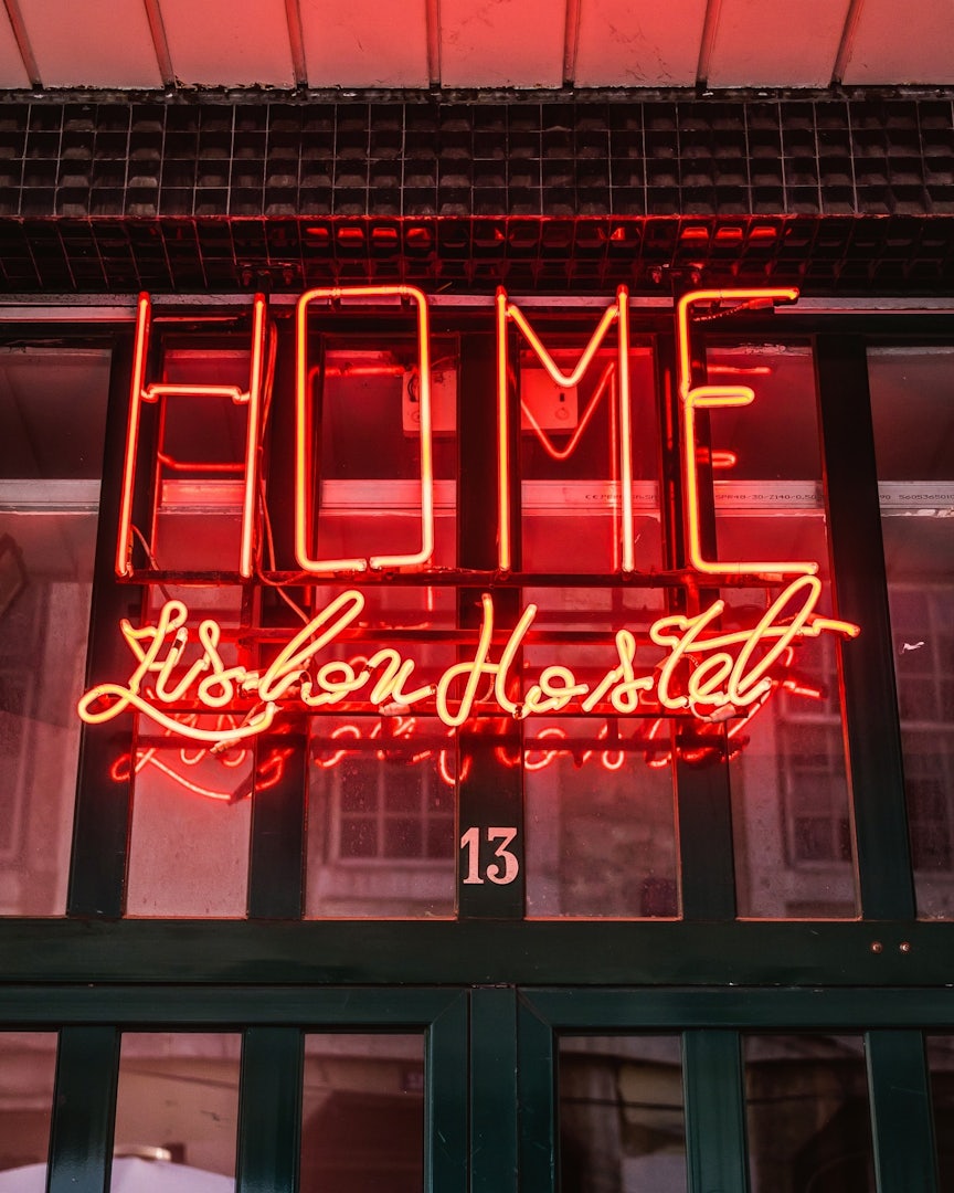 red neon sign of the Home hostel in Lisbon