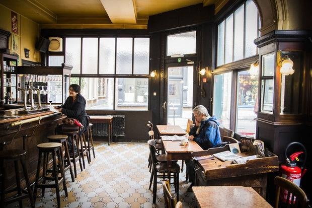 a man reading newspaper at Café De Kat