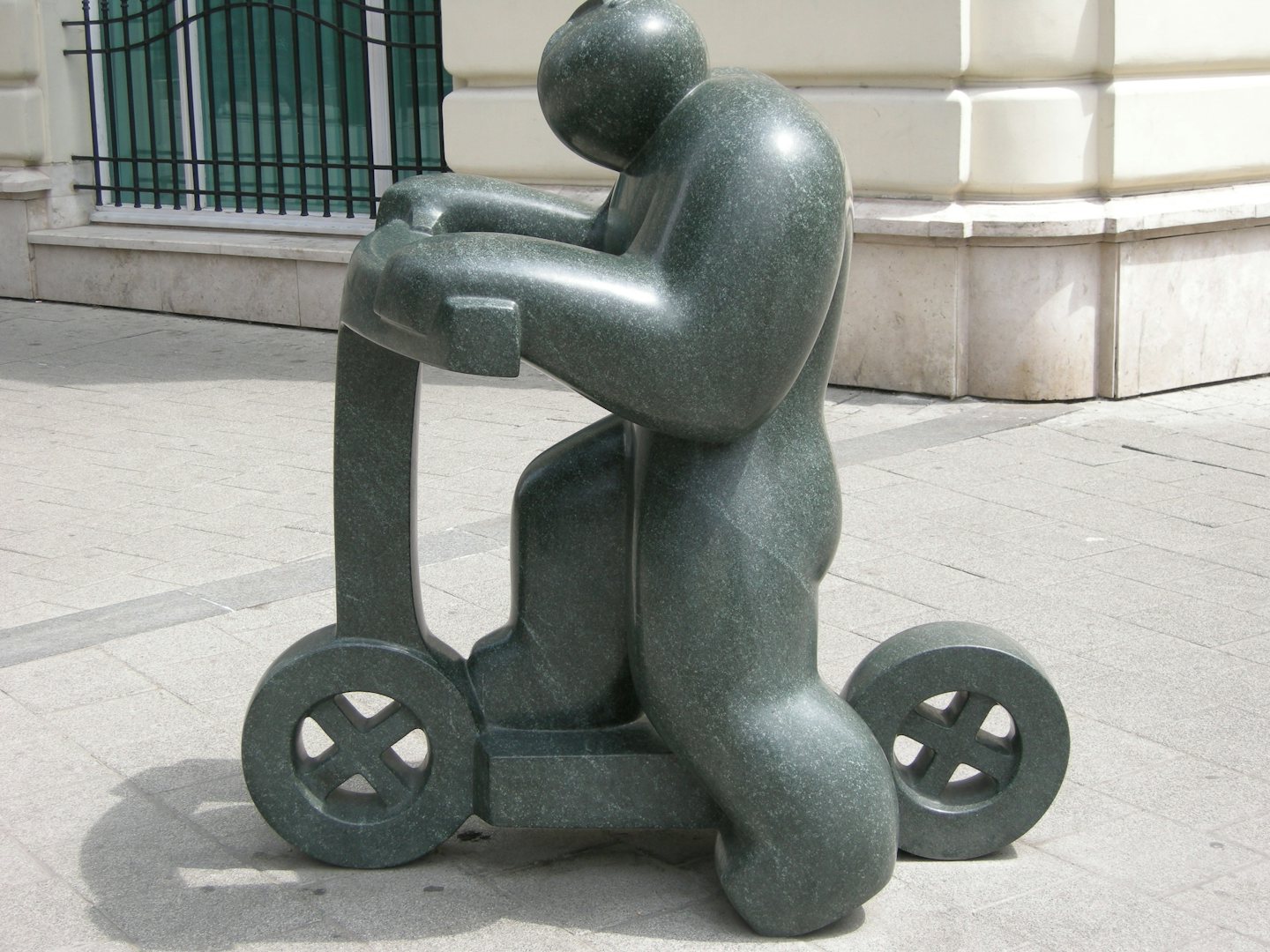 granite statue of a boy on a scooter