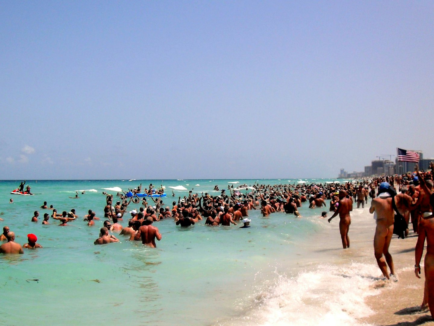 large group of nudists swimming at Haulover Park beach