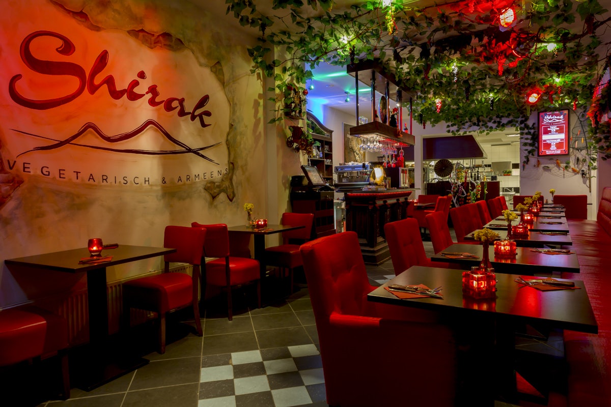 a red and dimly lighted interior of Shirak restaurant