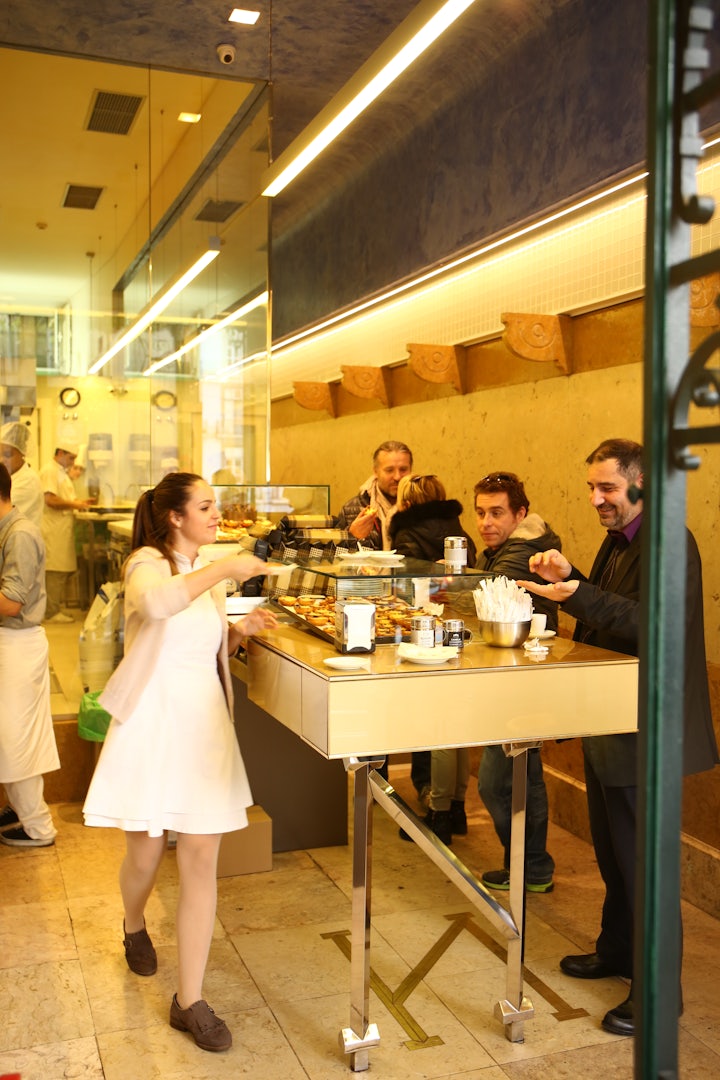 people eating pasteis de nata at Manteigaria