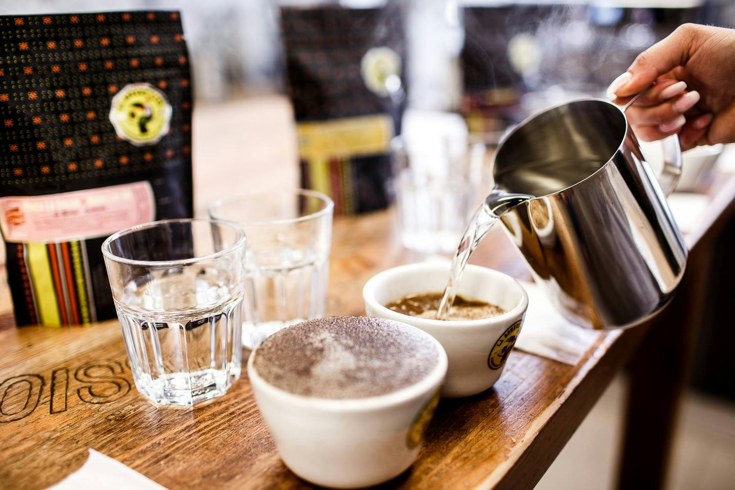 a hand pouring two coffees