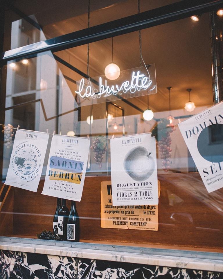 posters hanging in the window of La Buvette Paris