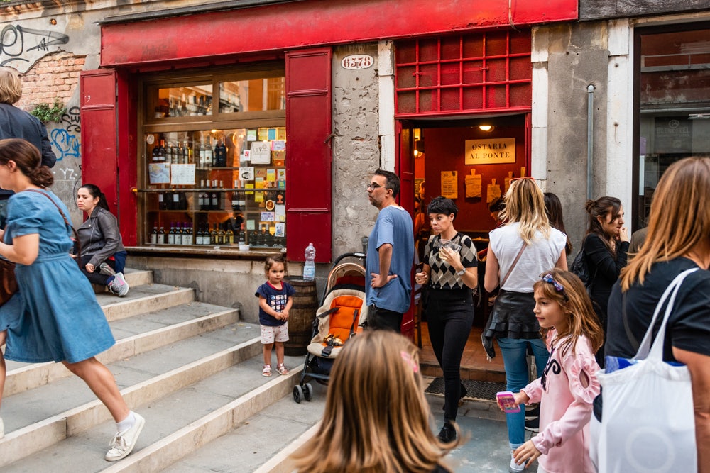 red exterior of the Ostaria Al Ponte and people 