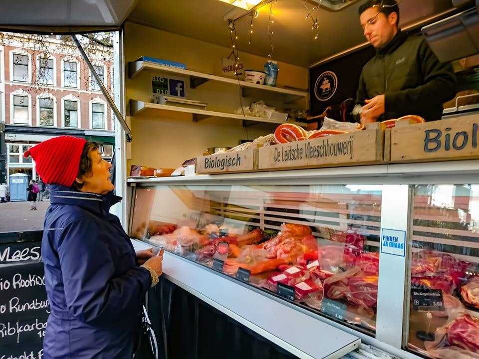 a woman buying meat at the Rotterdam Organic Market