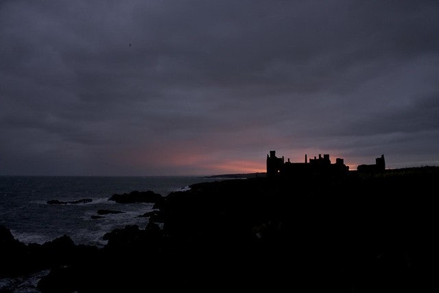 New Slains Castle in Scotland against a purple pink sky