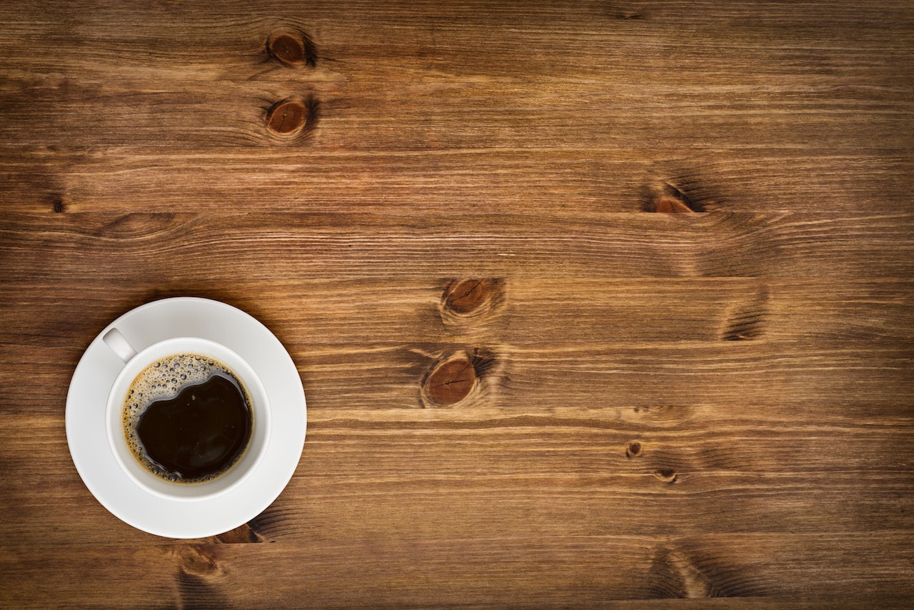 a cup of coffee on a wooden table