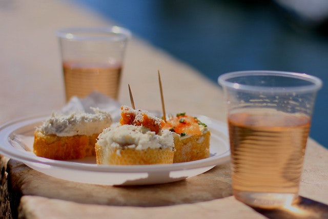 two glasses of rose wine with a plate of snacks