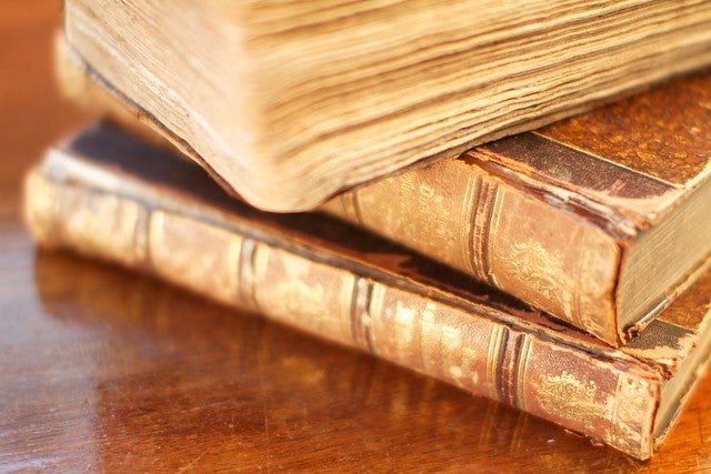 three antique books on a pile