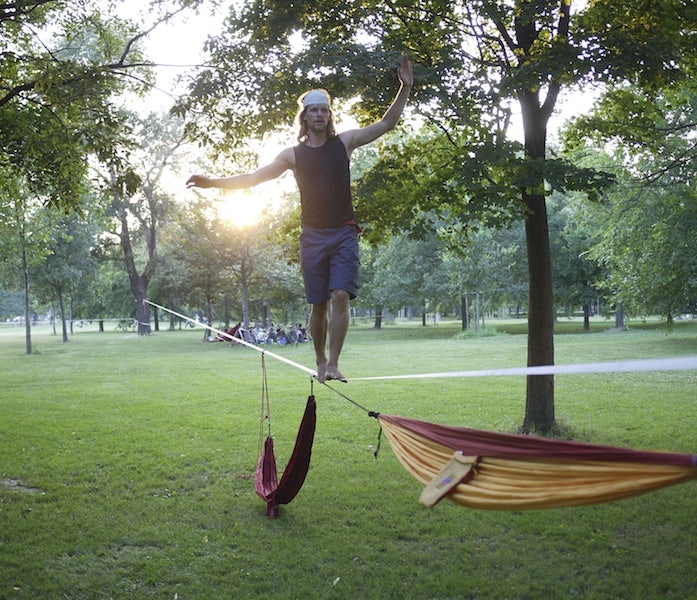 a man walking on a slack line in Prater park in Vienna