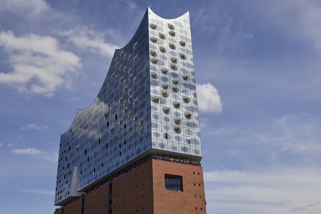 exterior of the Elbphilharmonie against a bright blue sky 