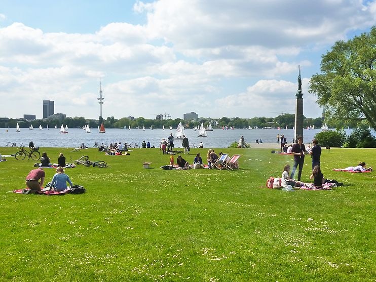 people enyoing the sun in the grass at Alsterwiese Schwanenwik