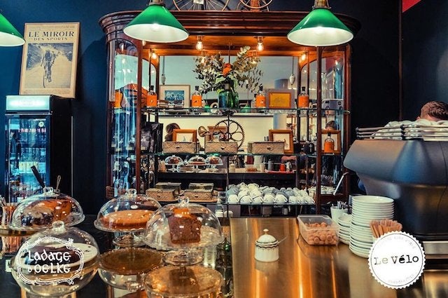 cakes displayed and the interior of Le Vélo Café