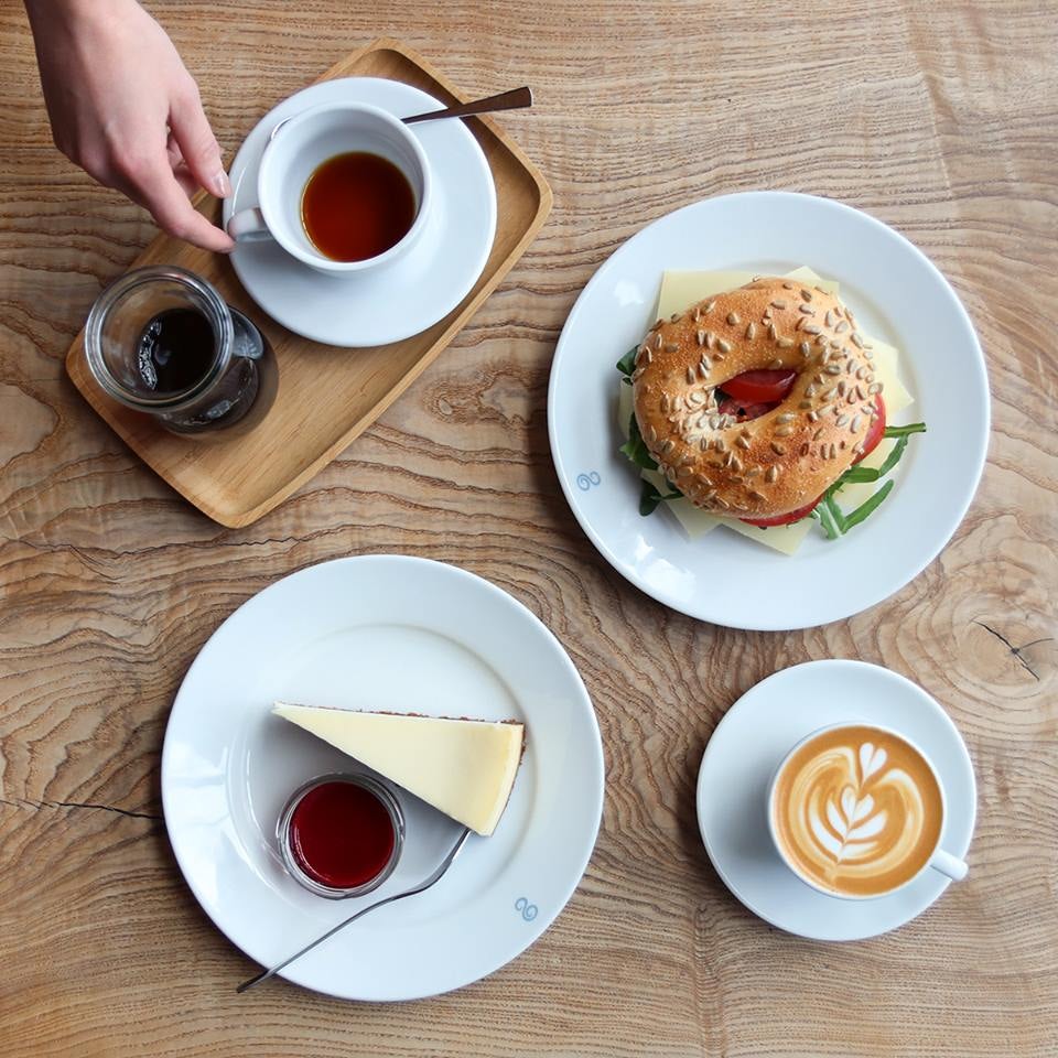 a cup of coffee and a bagel and cheesecake from Elbgold Hamburg