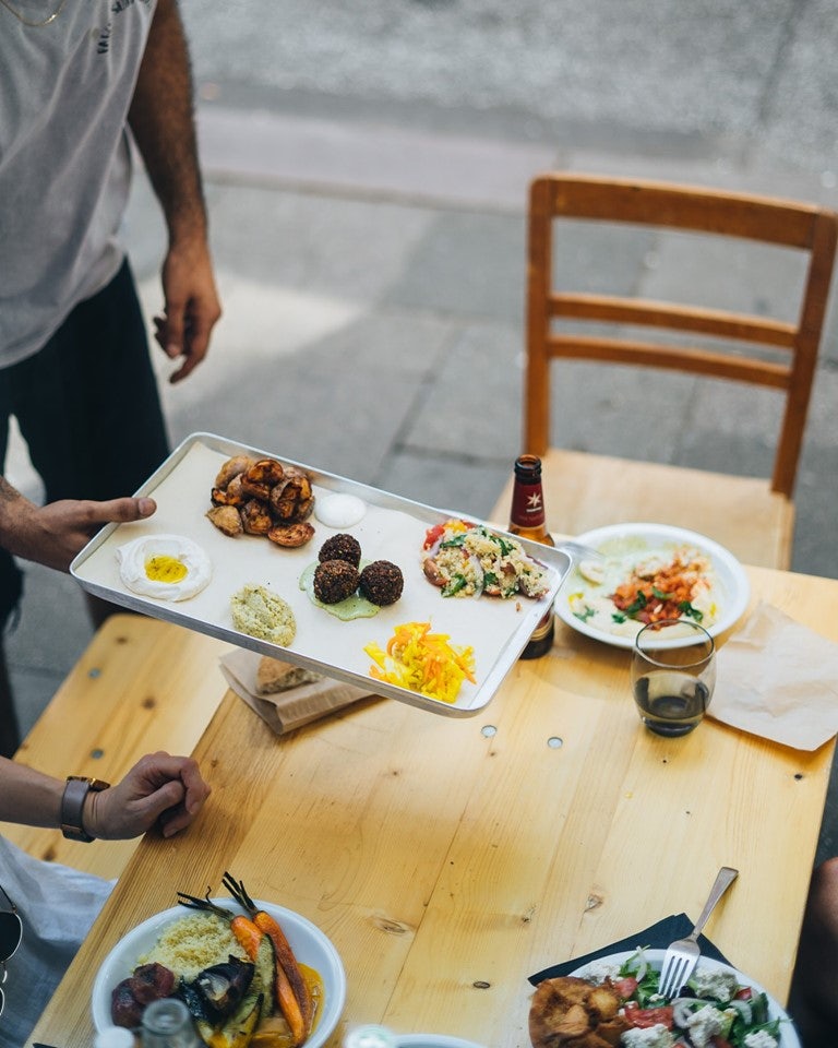 middle eastern food being served on a table at Simbiosa restaurant