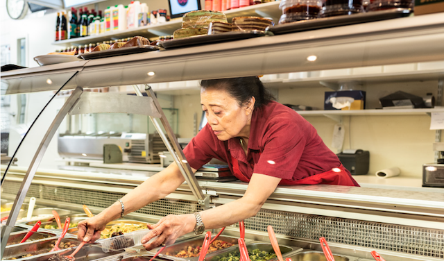 a woman getting Indonesian food at Toko Toet restaurant