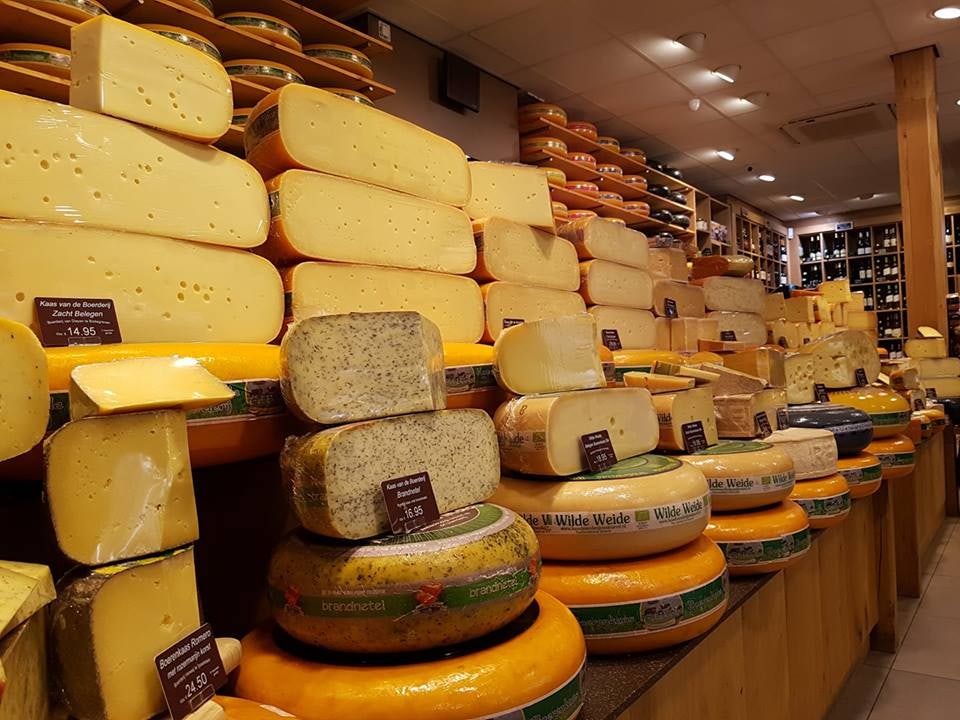 a wall stacked with rolls of cheese at Ed Boele store