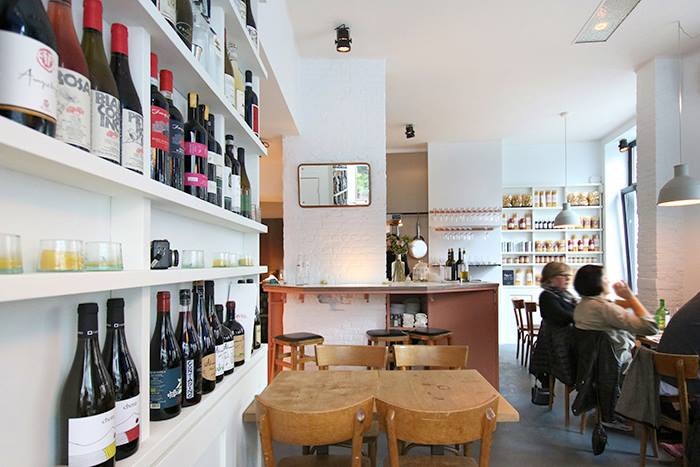 restaurant interior and wall stacked with wine bottles at Certo Brussels