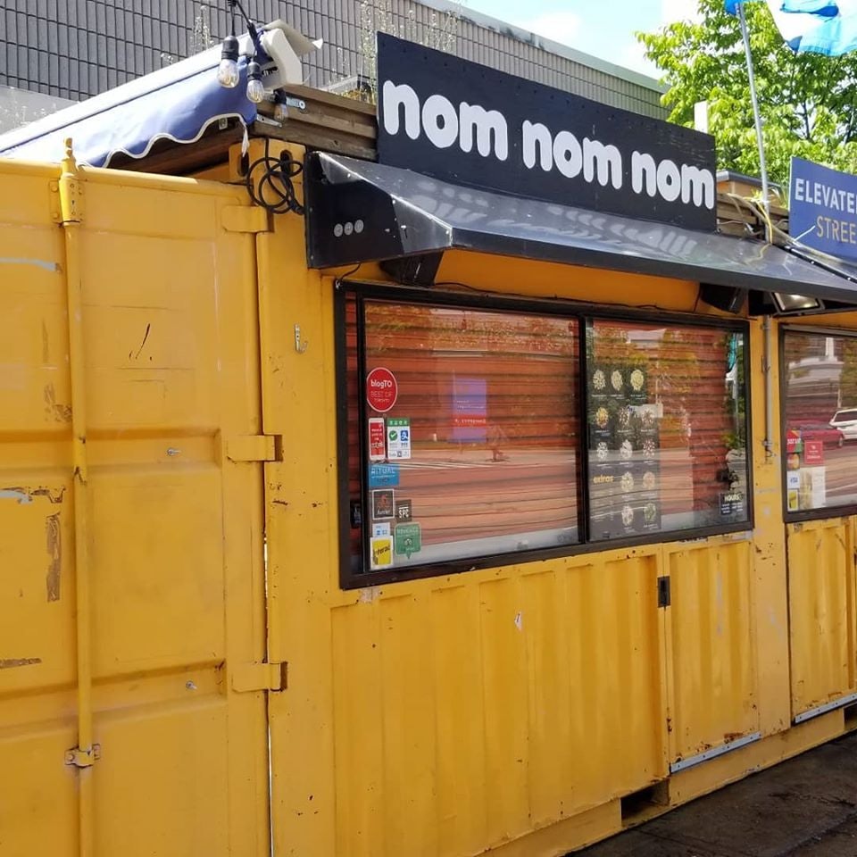 yellow exterior of Nom Nom Nom Poutine bar