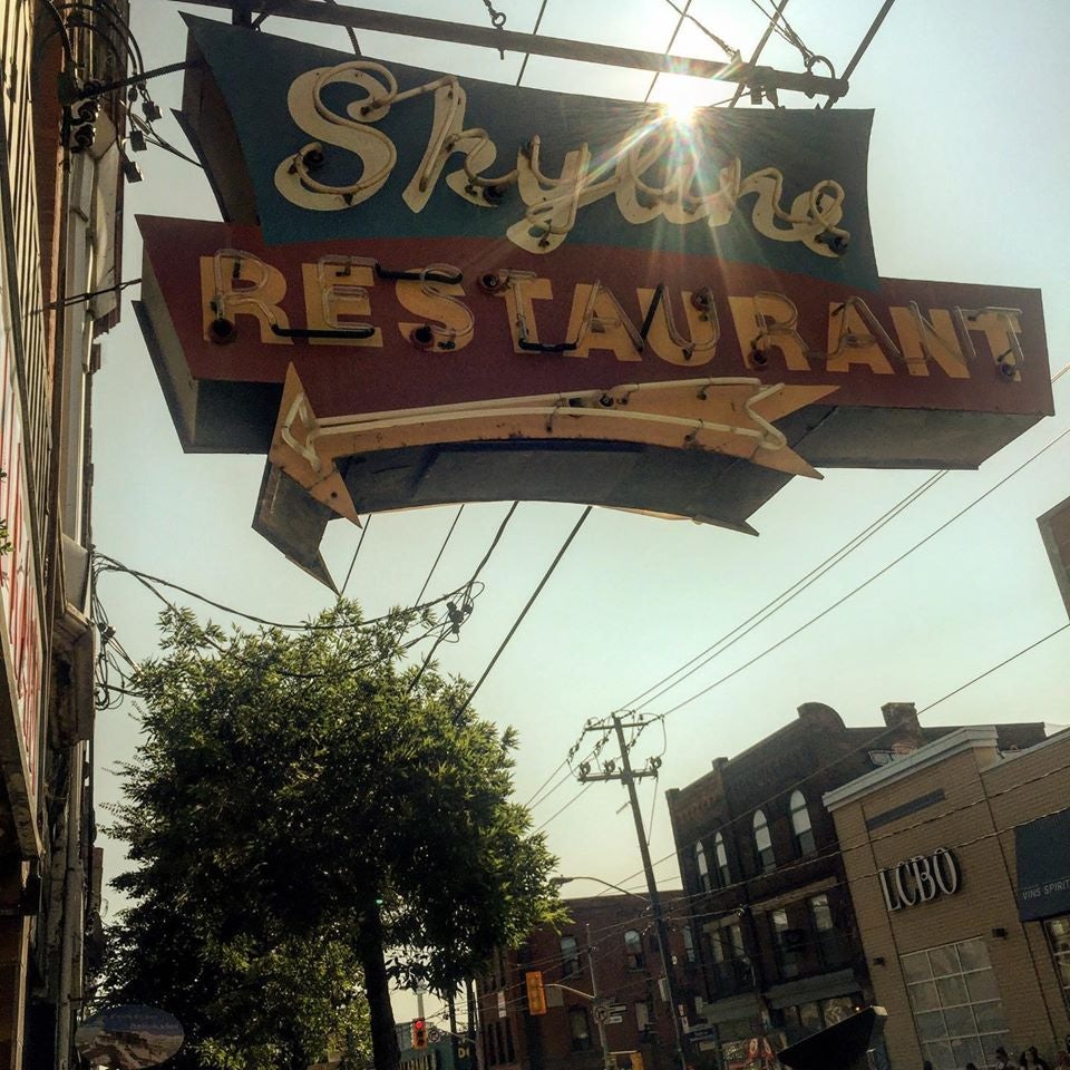 street sign of Skyline Restaurant with arrow