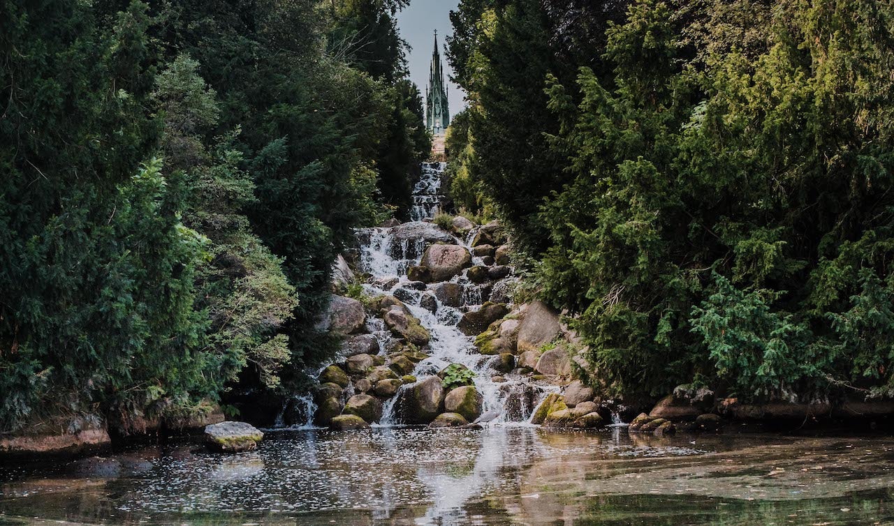 a waterfall surrounded by green at the Viktoriapark Berlin