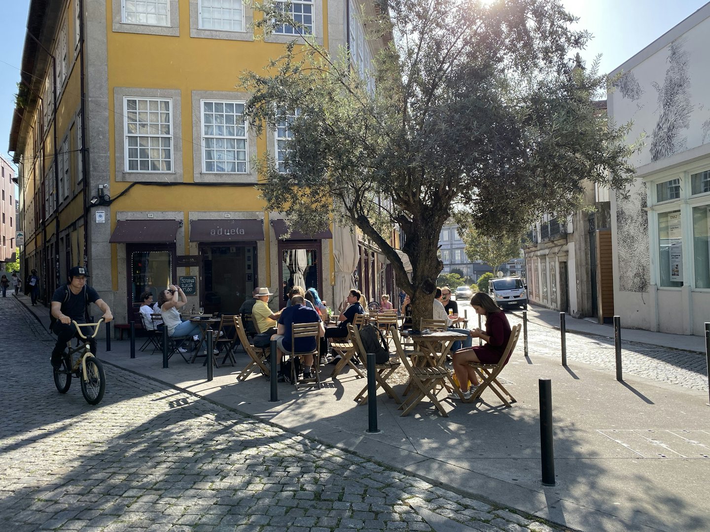 people having a drink outside on the sunny terrace of Aduela bar in Porto