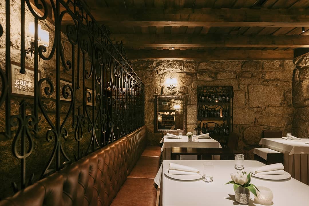 a cozy-lit interior of the O Paparico restaurant in Porto