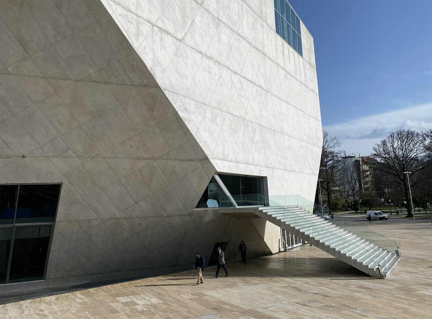 the minimal and exterior architecture of the Casa da Música against a blue sky