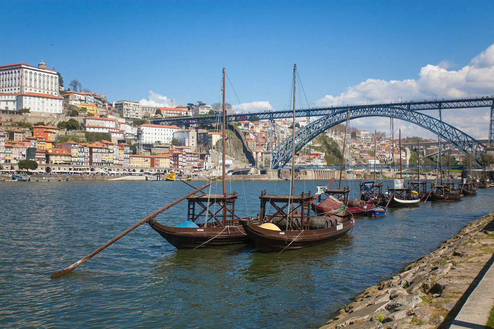two boats on the river in Porto and the Ponte Luis bridge in the background