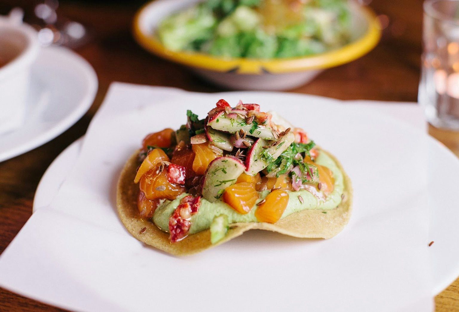 a taco from Caravelle bar with green sauce and vegetable toppings 