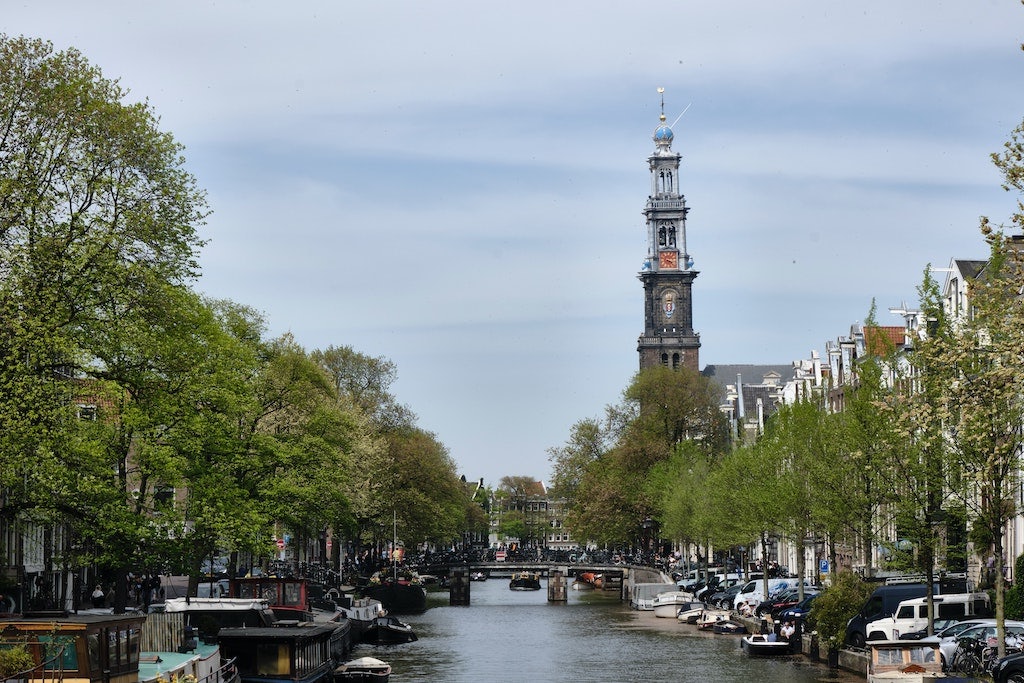 a view over the canal with the Westertoren in the background in Amsterdam