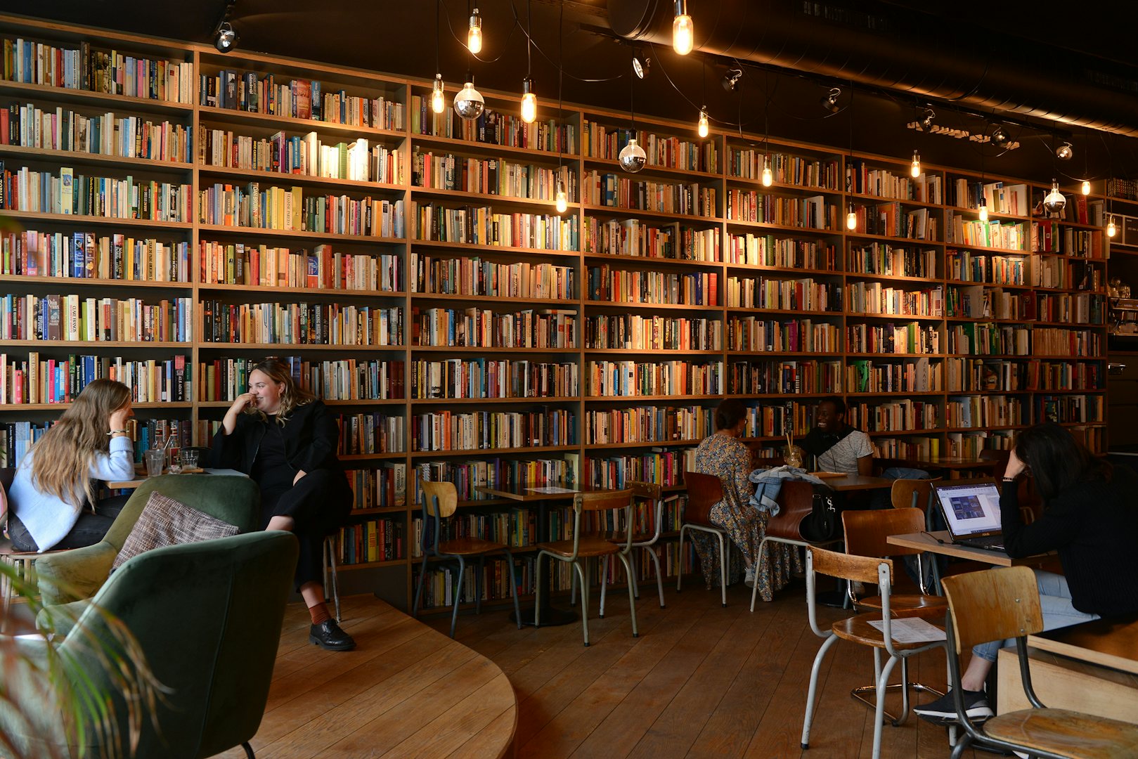 wall lined up with used books in the cafe at Le Bal Infernal in Ghent