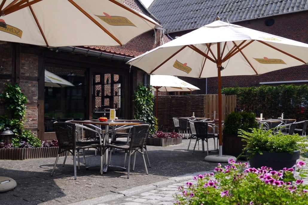 dining area and umbrellas at the outdoor terrace of De Gebrande Winning