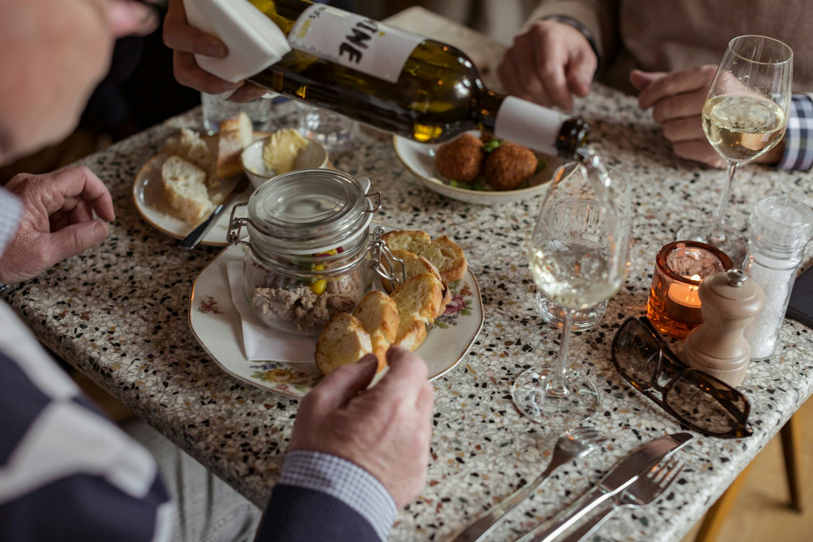 a dining table at Bodo restaurant with snacks and people dining