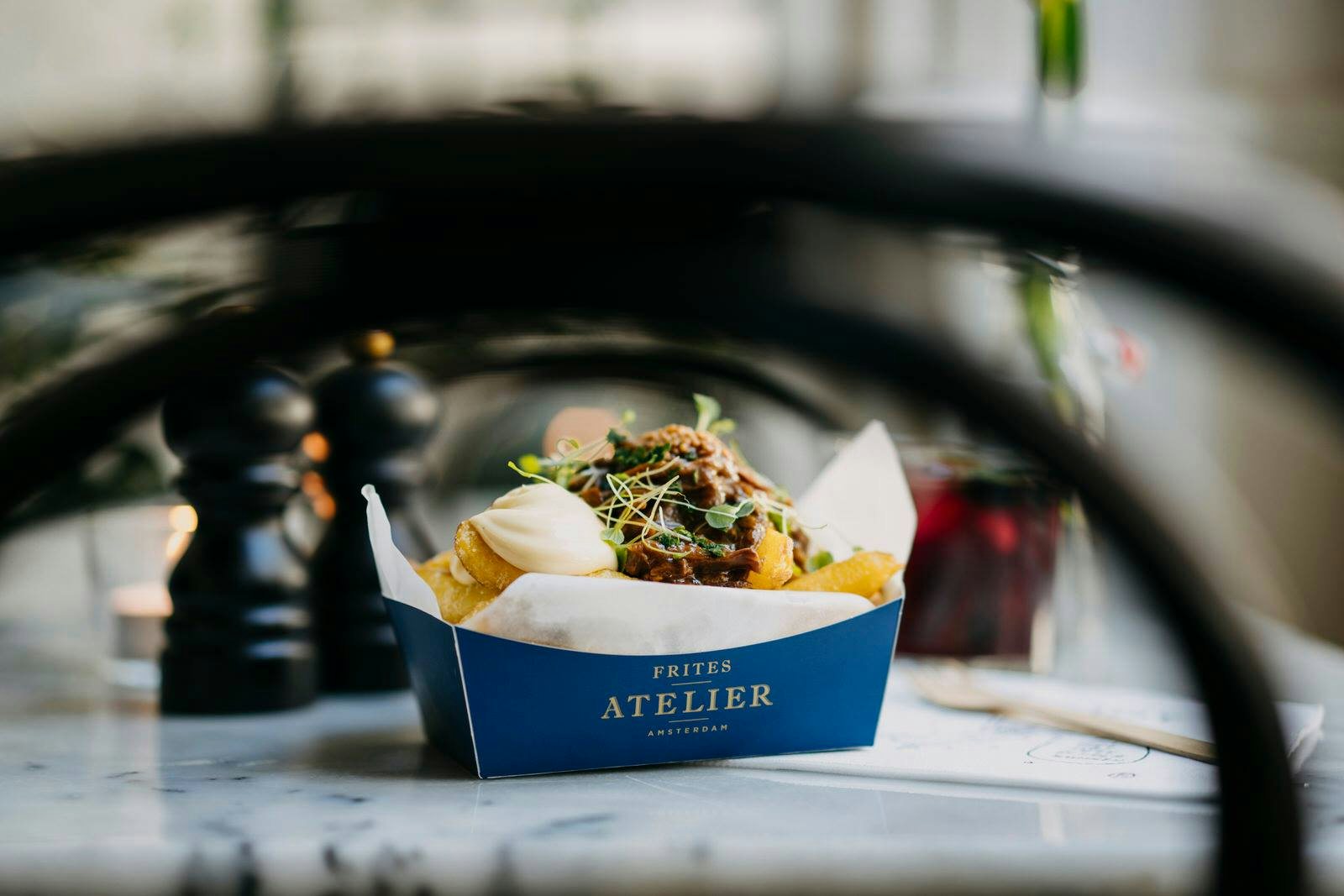 a box of fries with sauce and toppings from Frites Ateliers