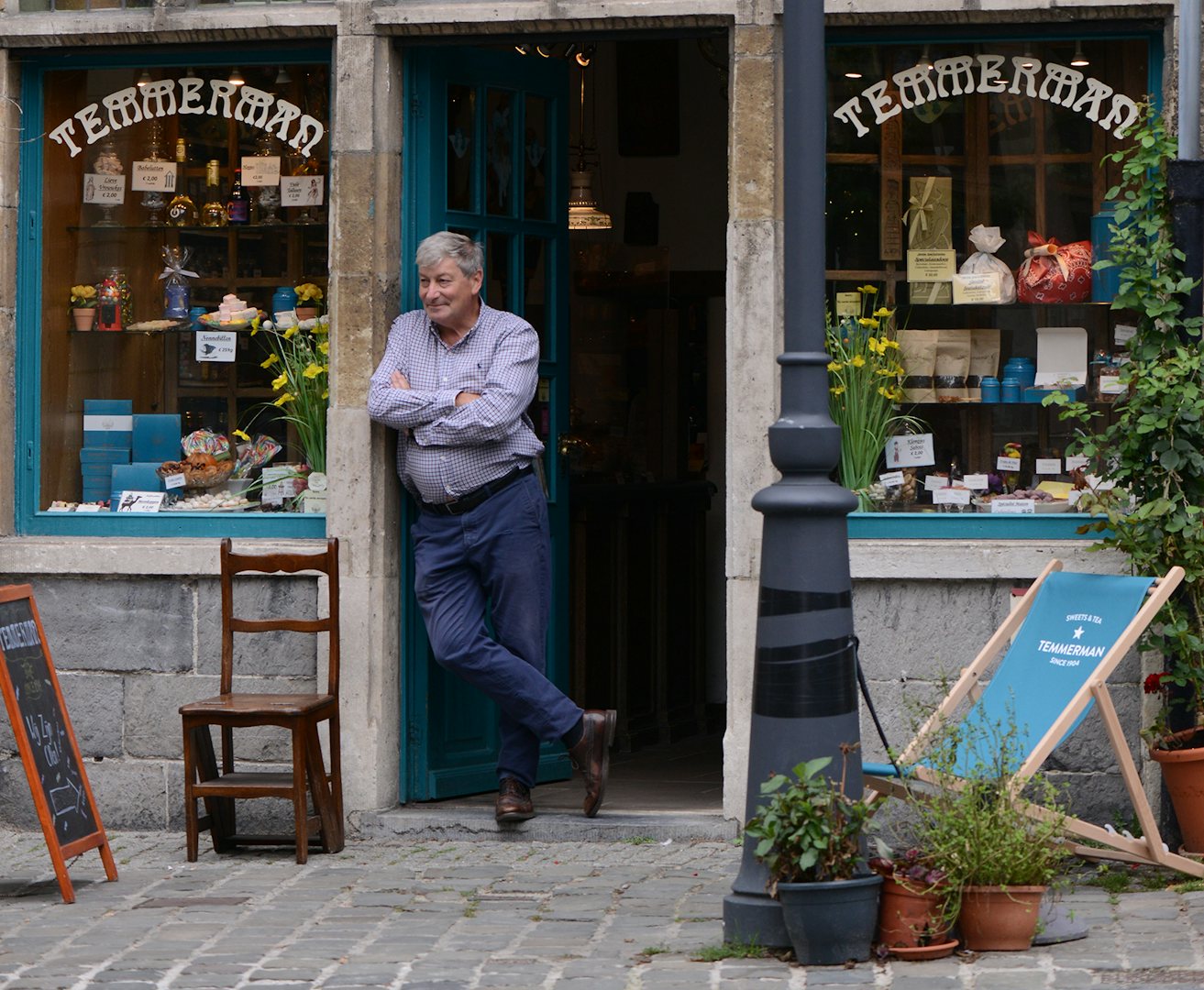 the owner of Confisserie Temmerman in the portal of the shop