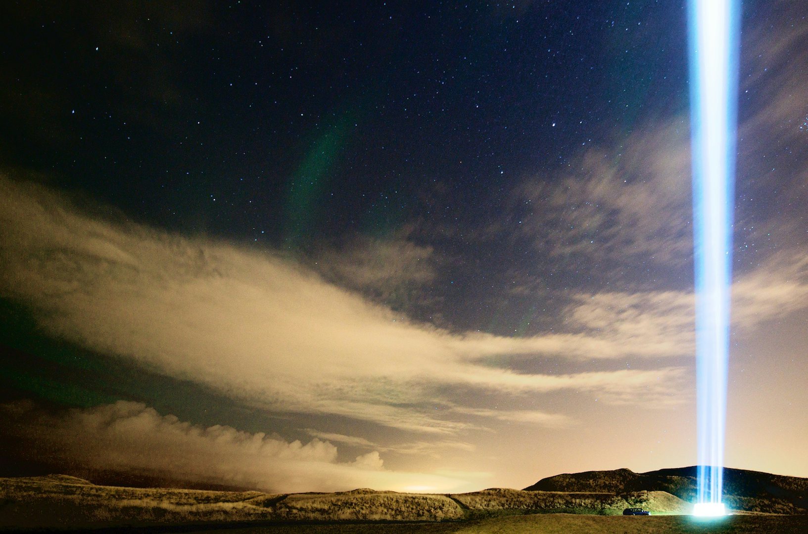 Imagine Peace Tower at night shining a strong light in the sky