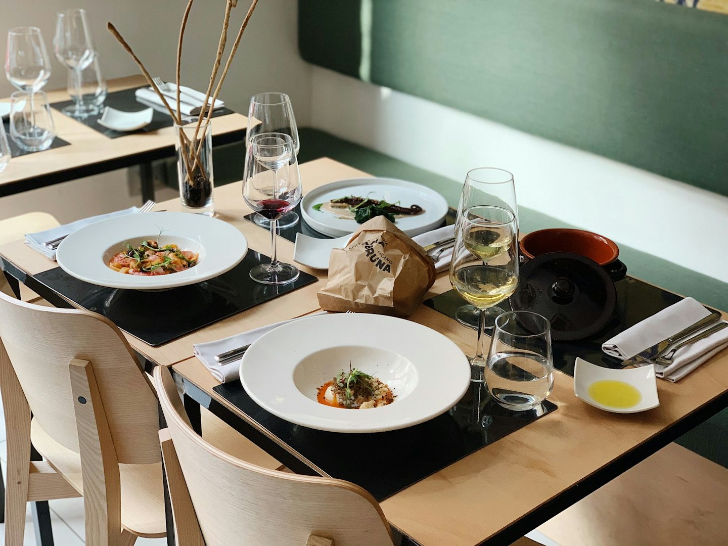 Set table with wine and pasta dishes at Orma Bruna in Milan