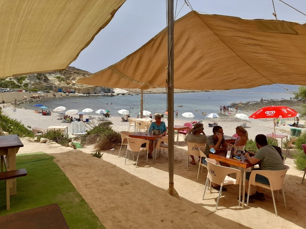 people enjoying the beach at the Crab Shell kiosk in Qlendi