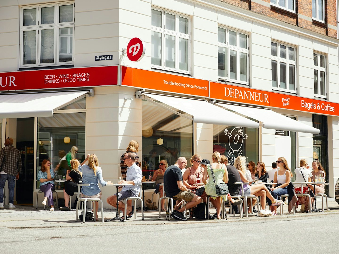 People sitting on the sunny terrace of Depanneur