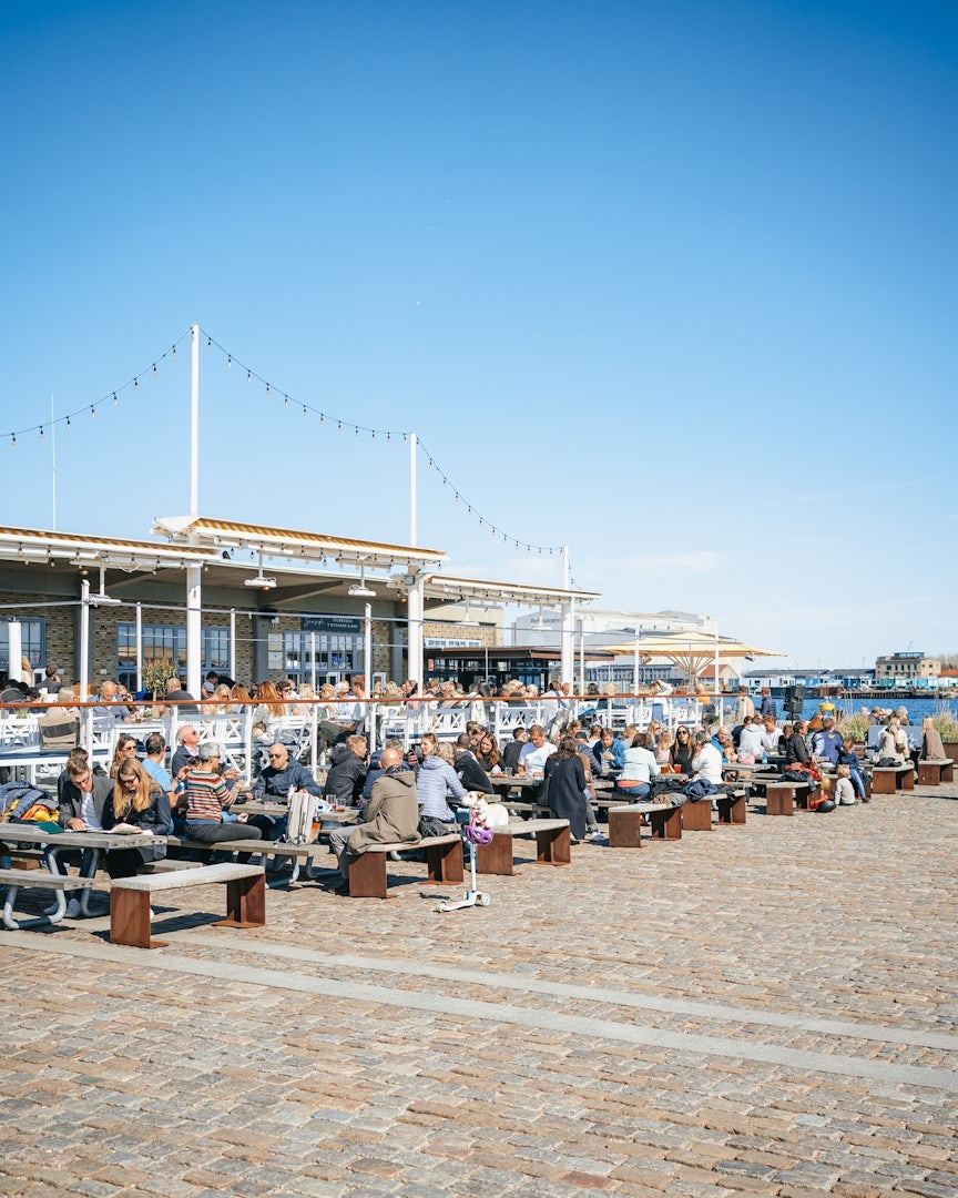 People sitting on benches on the terrace of Seaside Toldboden