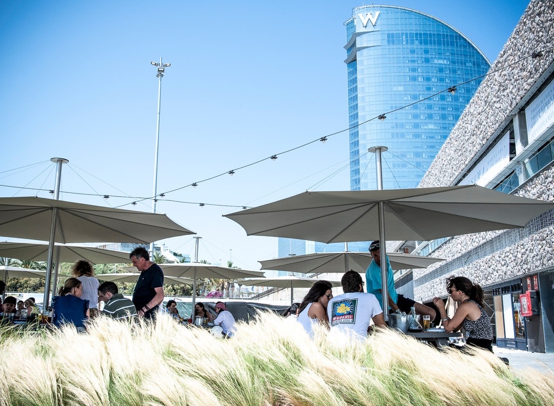 Terrace of Camping Mar with parasols and view of the W Hotel