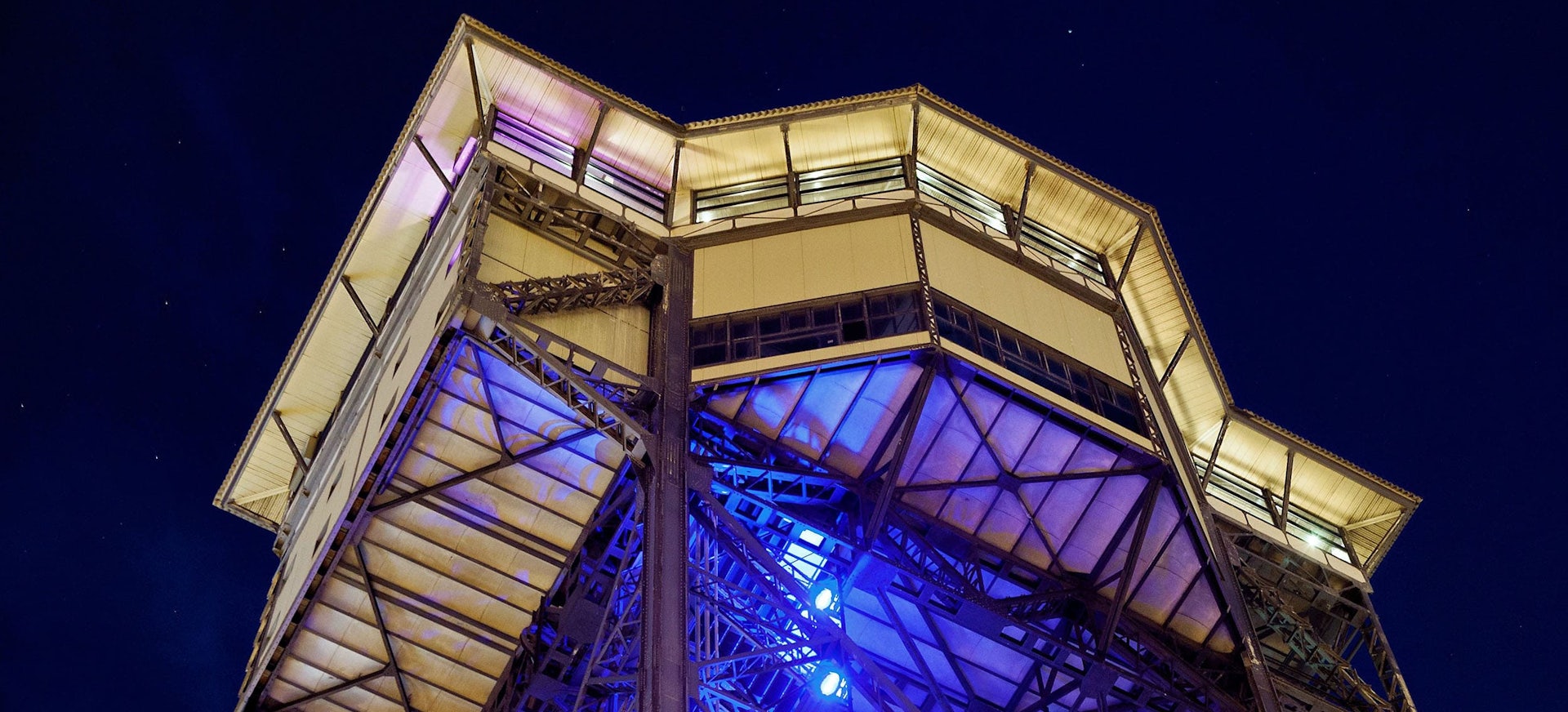 Bottom view of the lit up Torre de Alta Mar restaurant in Barcelona